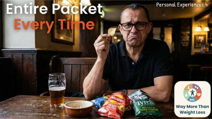 Man in pub holding crisp with frustrated expression surrounded by crisp packets