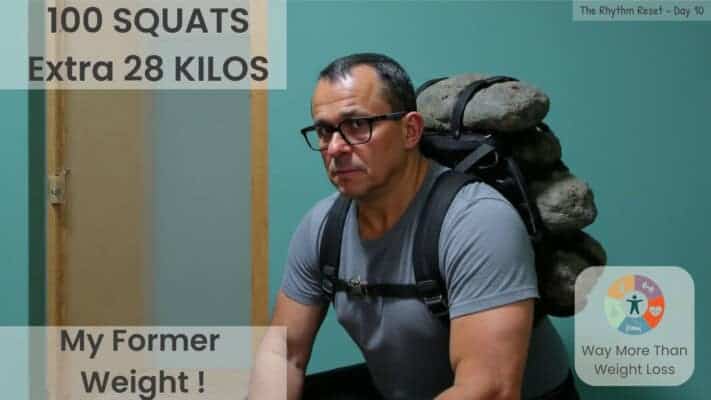 Man in weighted rucksack with 28kg stones doing squats. Text: 100 squats, extra 28 kilos, my former weigh