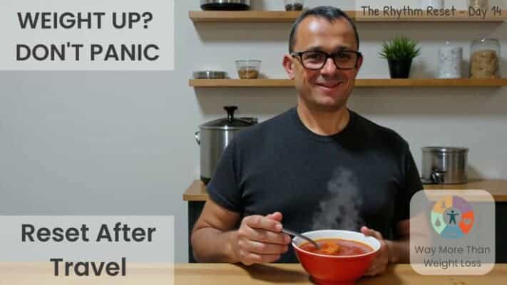 Man in black shirt smiling at kitchen table with red bowl of soup. Text reads "Weight Up? Don't Panic - Reset After Travel"