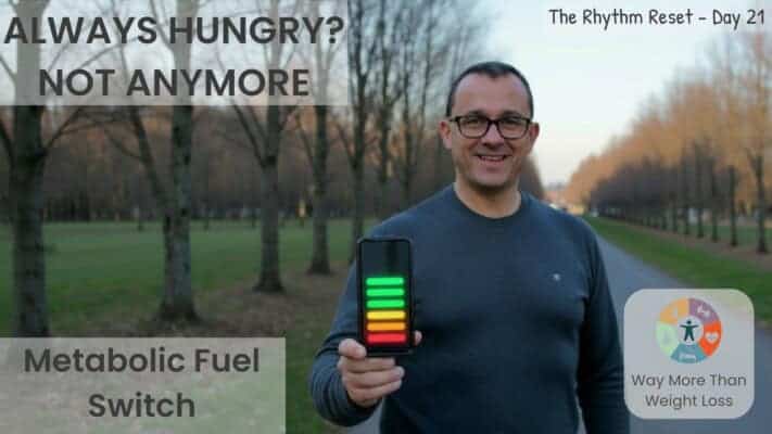 Man showing metabolic tracking app during autumn park walk demonstrating hunger-free fasting
