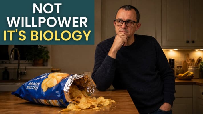 Neil beside an open crisp packet in his kitchen at night
